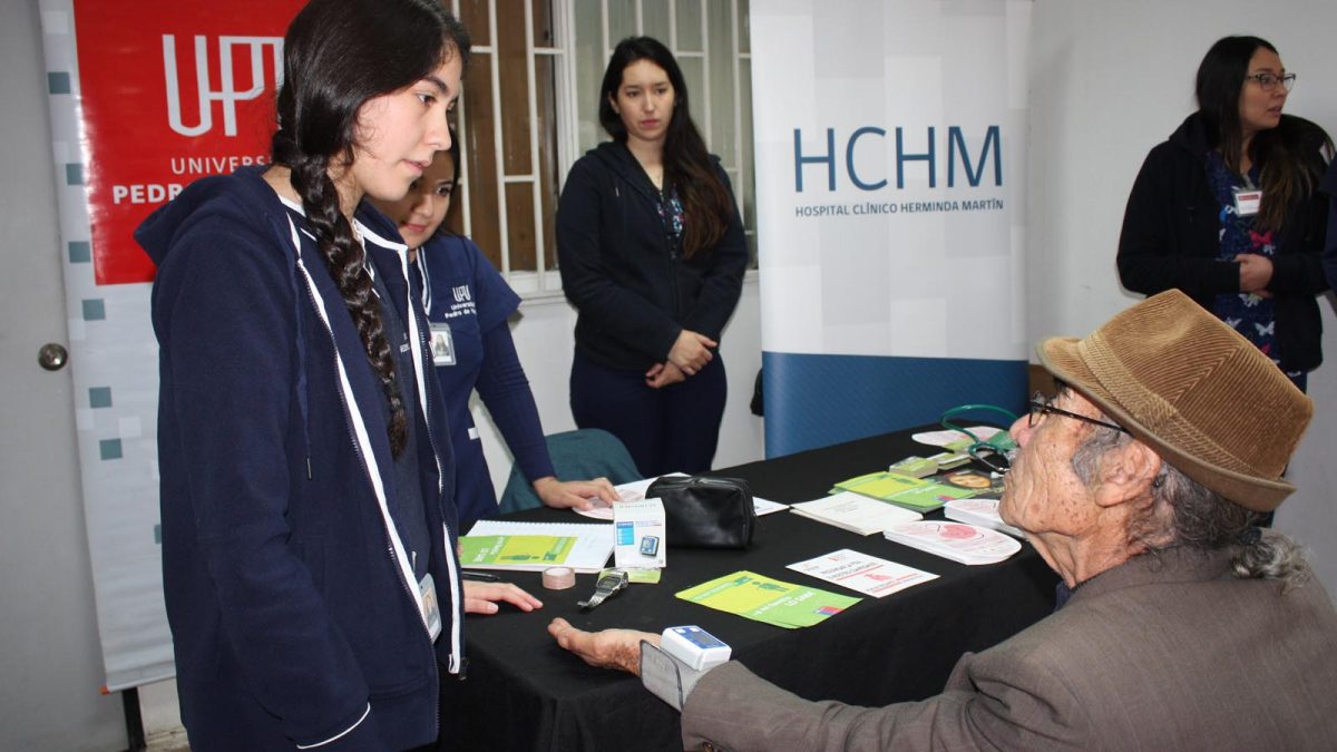 Imagen de adulto mayor tomándose la presión arterial en puesto informativo en el marco de la conmemoración de la Semana del Riñón en el Hospital de Chillán.